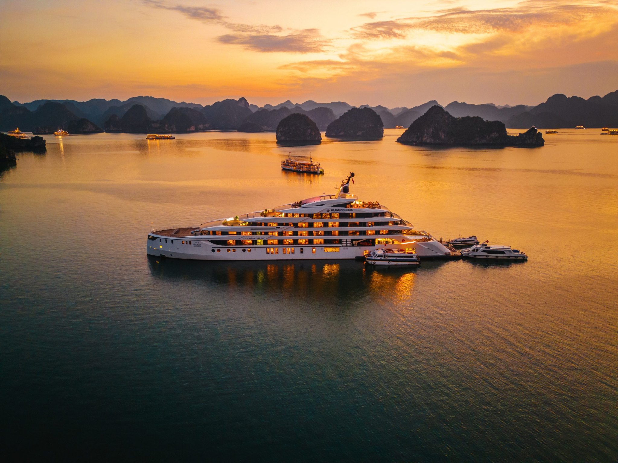 Luxury cruise ship at sunset among the limestone islands of Ha Long Bay