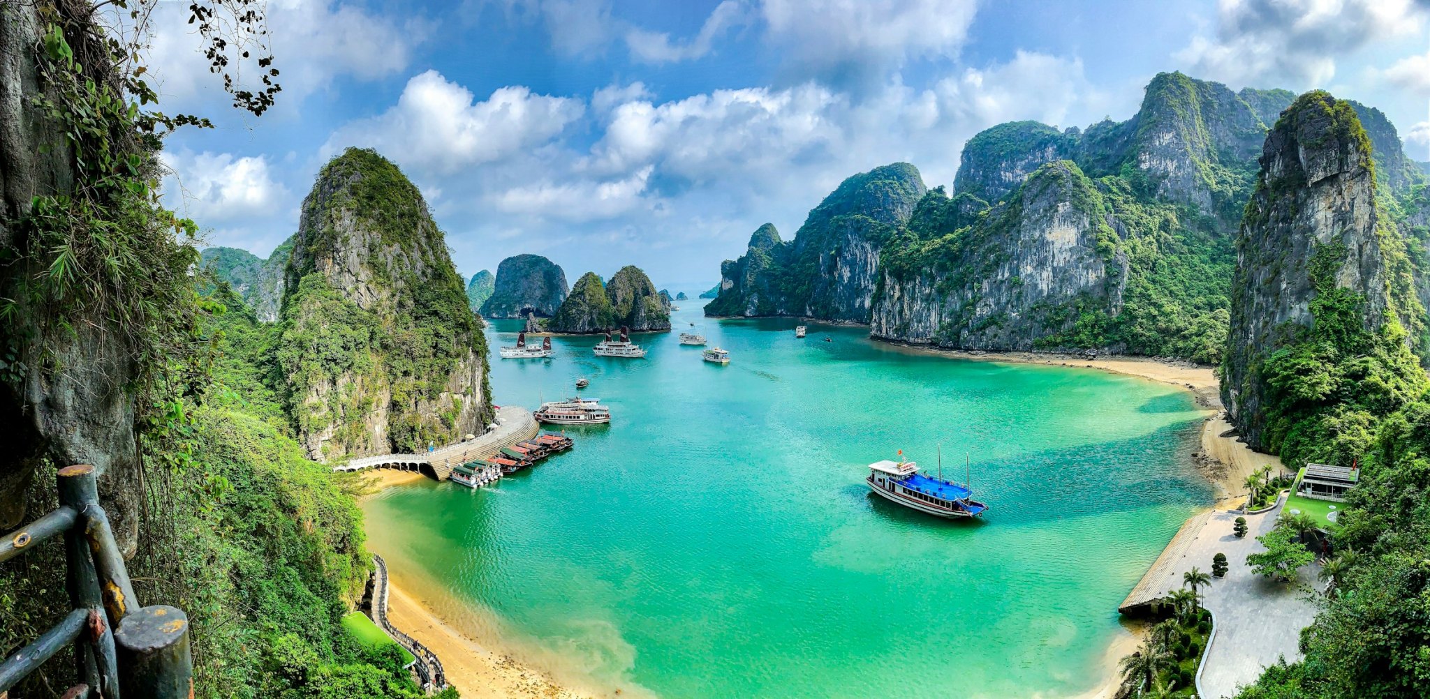 Boats on the turquoise water of Ha Long Bay surrounded by limestone karst islands