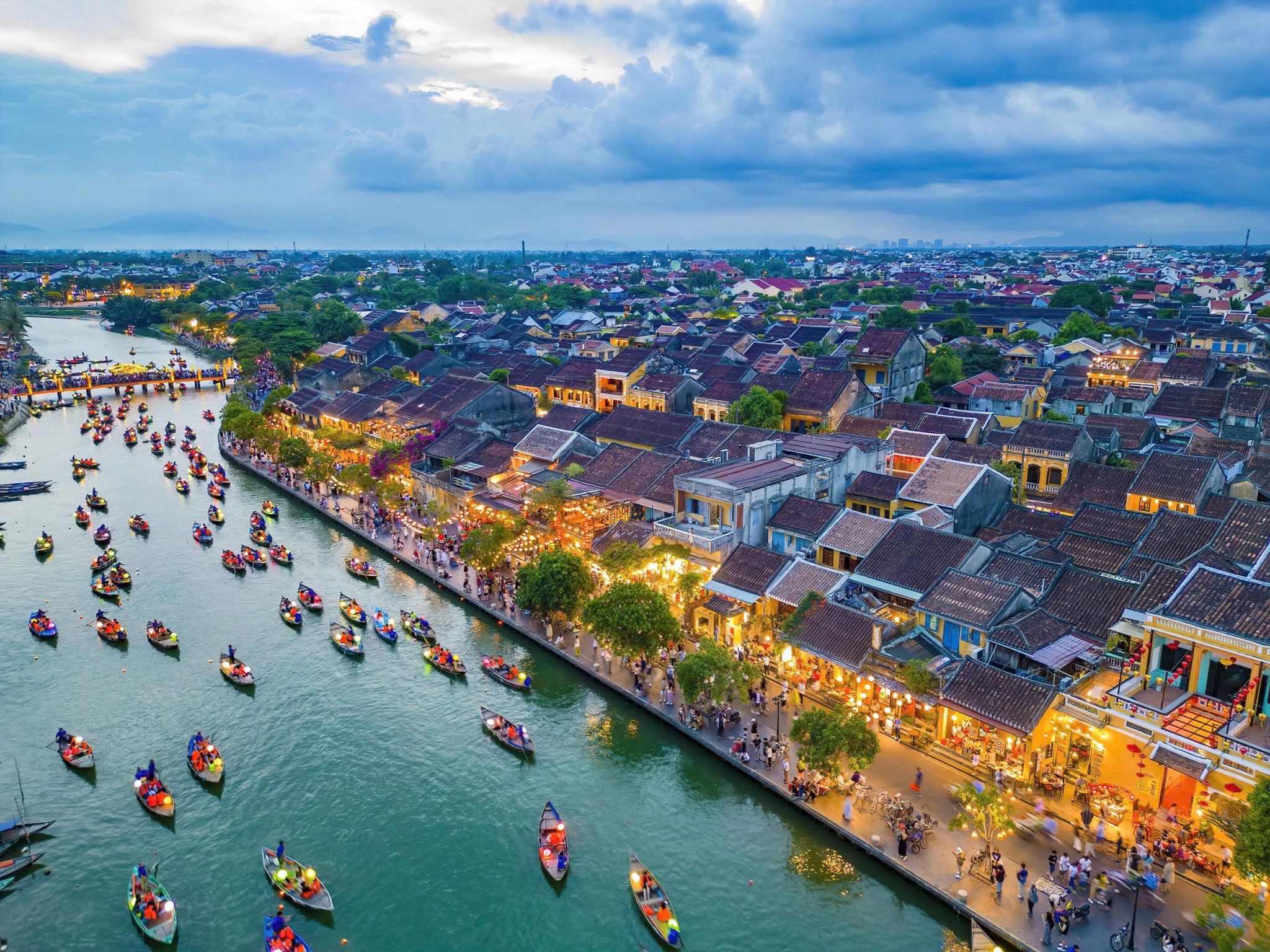 Aerial view of Hoi An Ancient Town and lantern boats on the Thu Bon River at dusk
