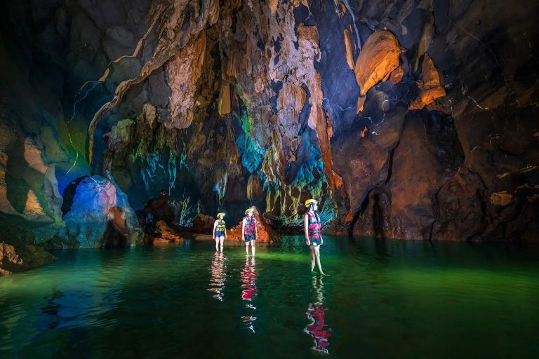 Wading through the underground river of Dark Cave (Hang Toi) - Rose Travel