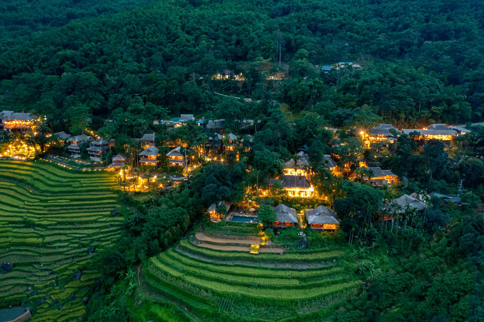 Stilt-house retreat among rice terraces and forest in Pu Luong at dusk