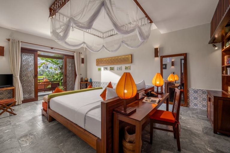 Boutique hotel room in Hoi An with a canopy bed and silk lanterns