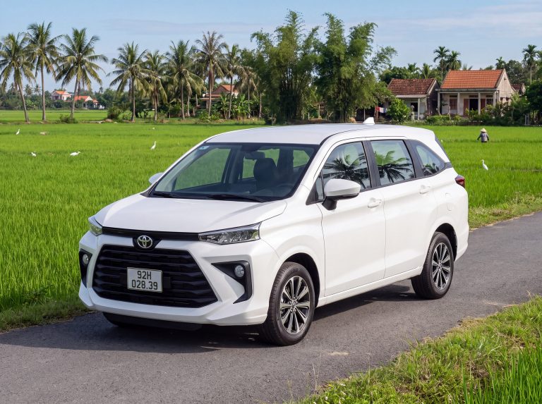 Rose Travel Toyota Avanza 7-seater private car on a country road by rice fields near Hoi An, plate 92H-028.39